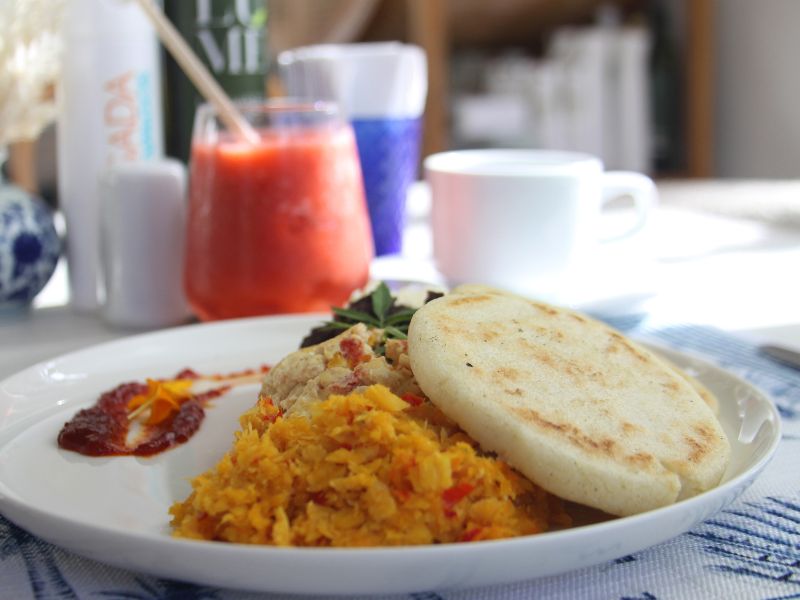 Arepa con perico, jugo natural y desayuno incluido en pensión completa en Posada Galápagos, Los Roques